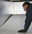 contractor installing TerraBlock™ floor insulation in a Minden crawl space